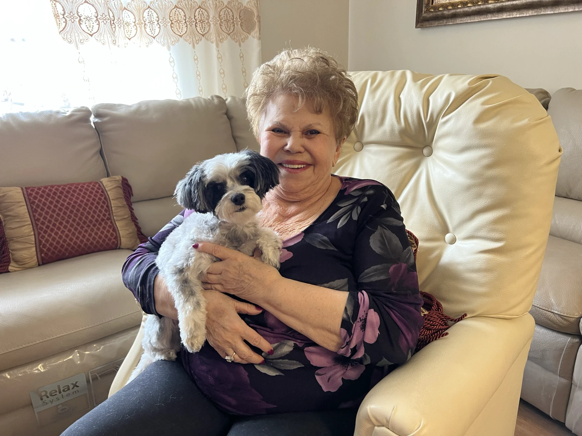 Elderly woman holding small black and white dog