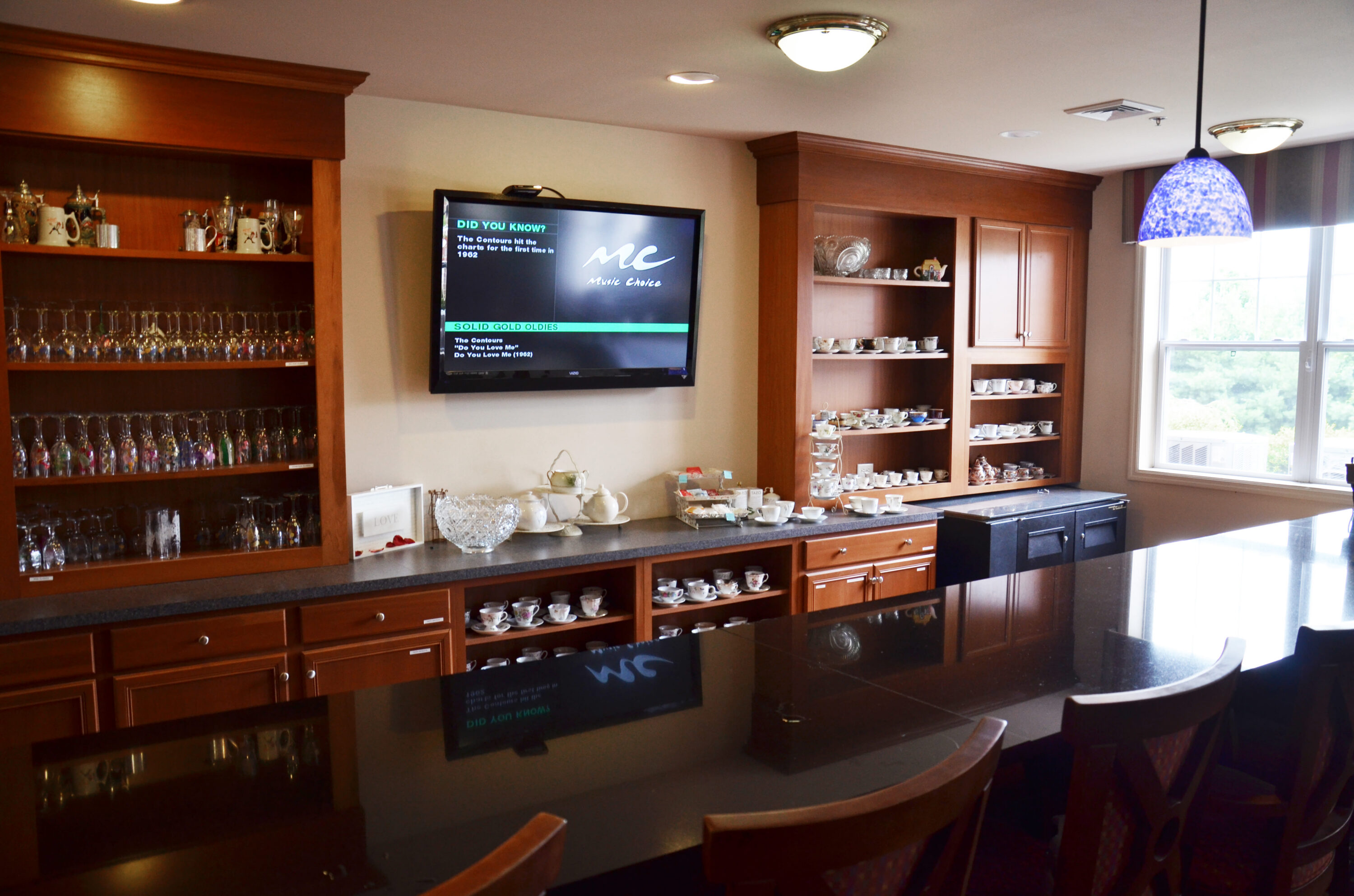 Cozy kitchenette with wooden cabinets and wall-mounted TV