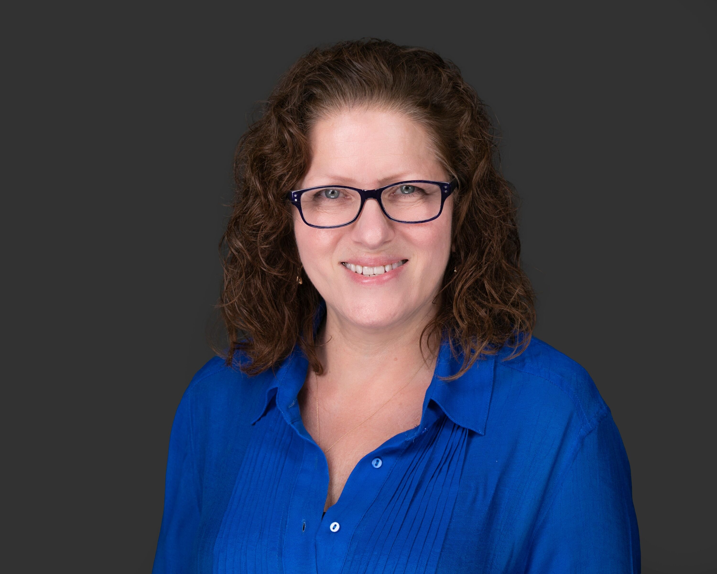Professional headshot of woman in blue blouse