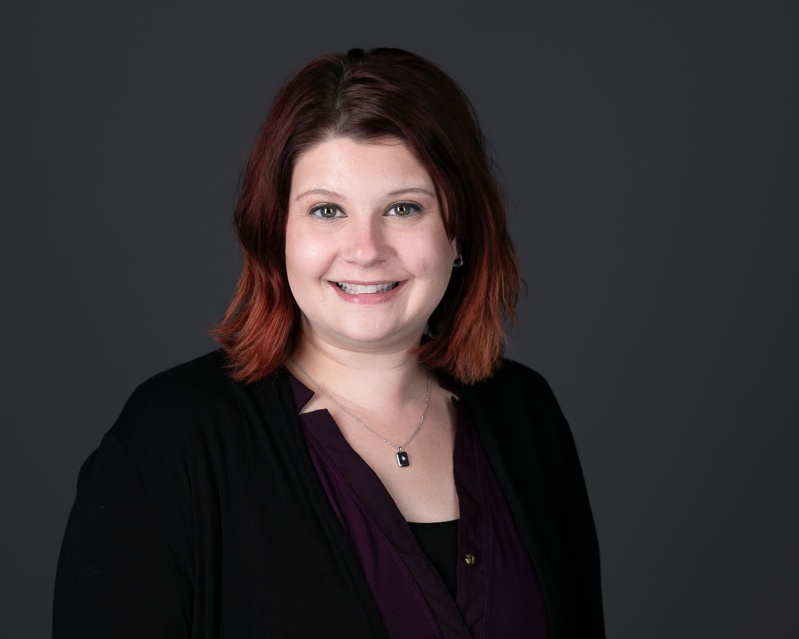 Professional headshot of smiling woman with red hair