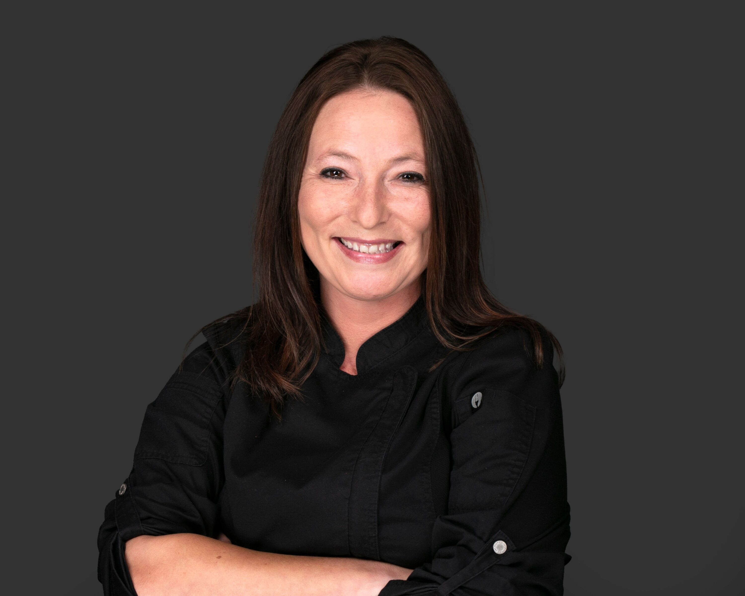 Smiling chef in black uniform portrait